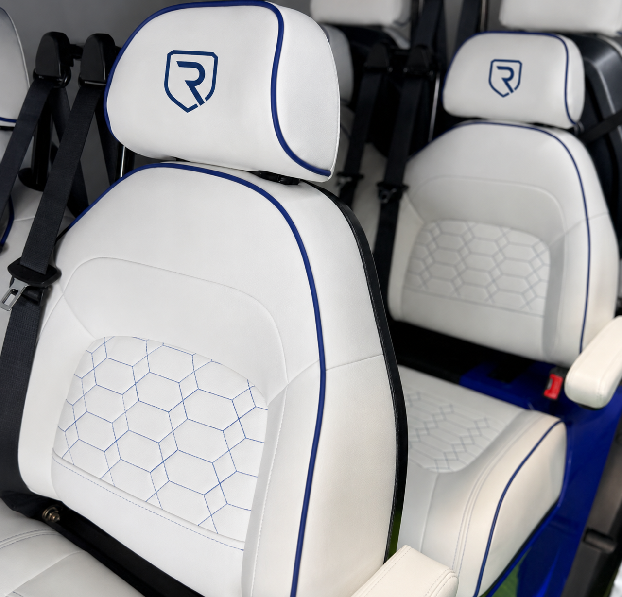 Embroidered Riviera logo on white premium leather headrests with blue piping
