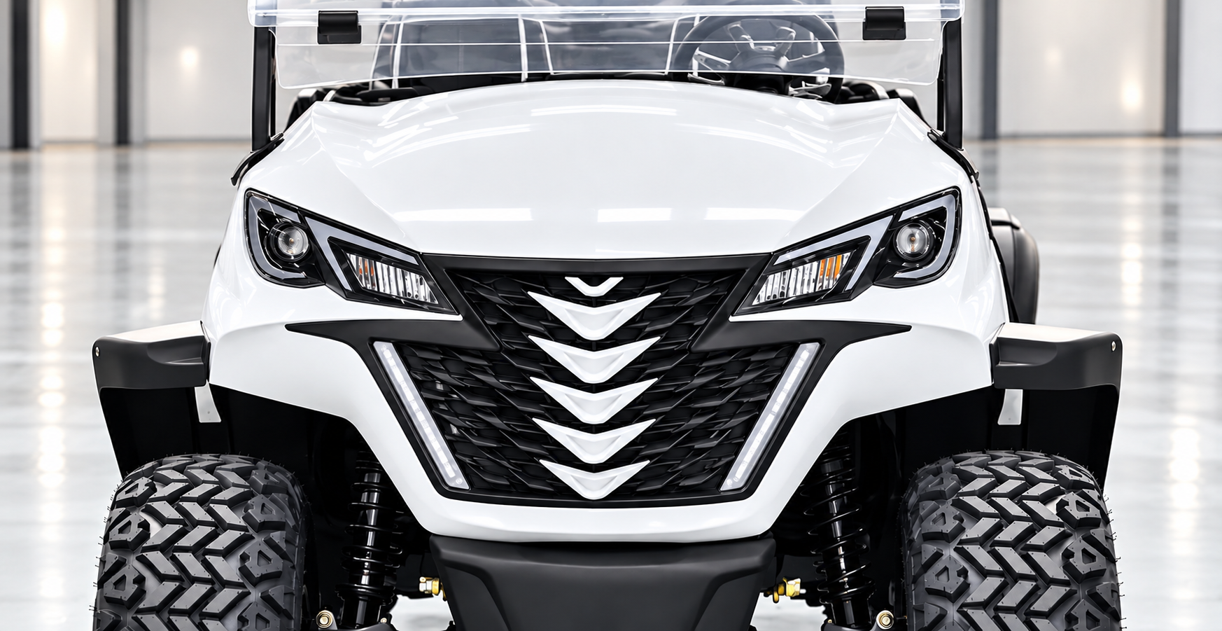 Riviera front fascia: chevron black grille with LED daytime running lights on a white luxury golf cart